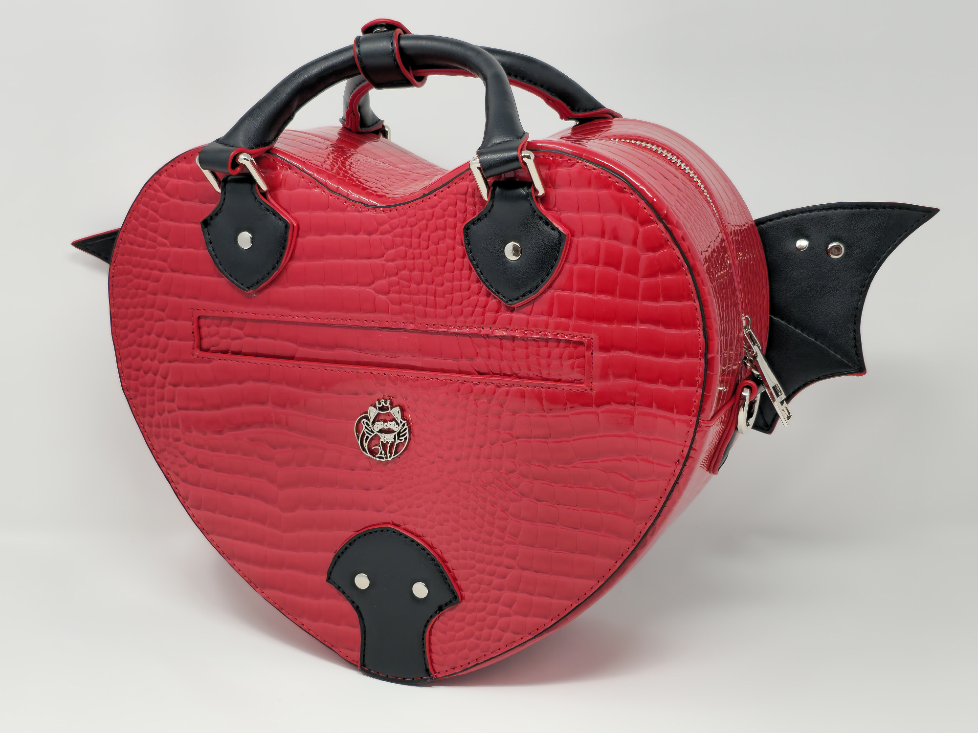 Back view of red faux snakeskin heart bag with bat wings, zipper pocket, and gothic emblem detail