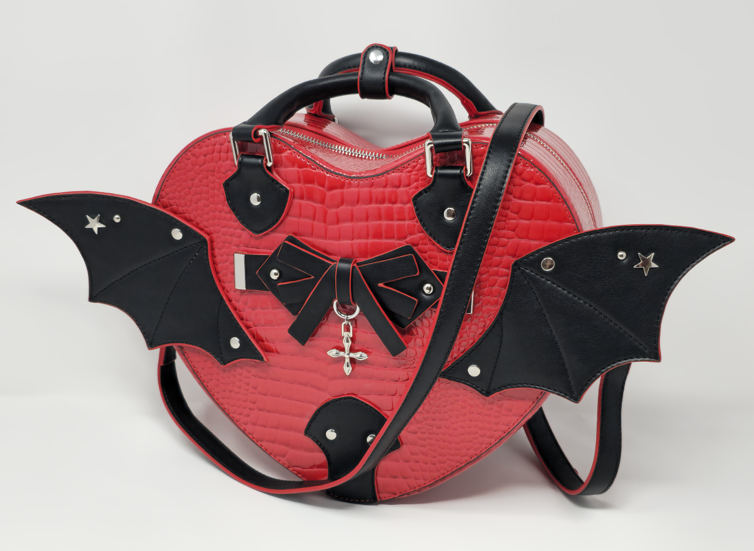 Gothic heart-shaped handbag with bat wings, faux snakeskin texture, and crossbody strap in red and black