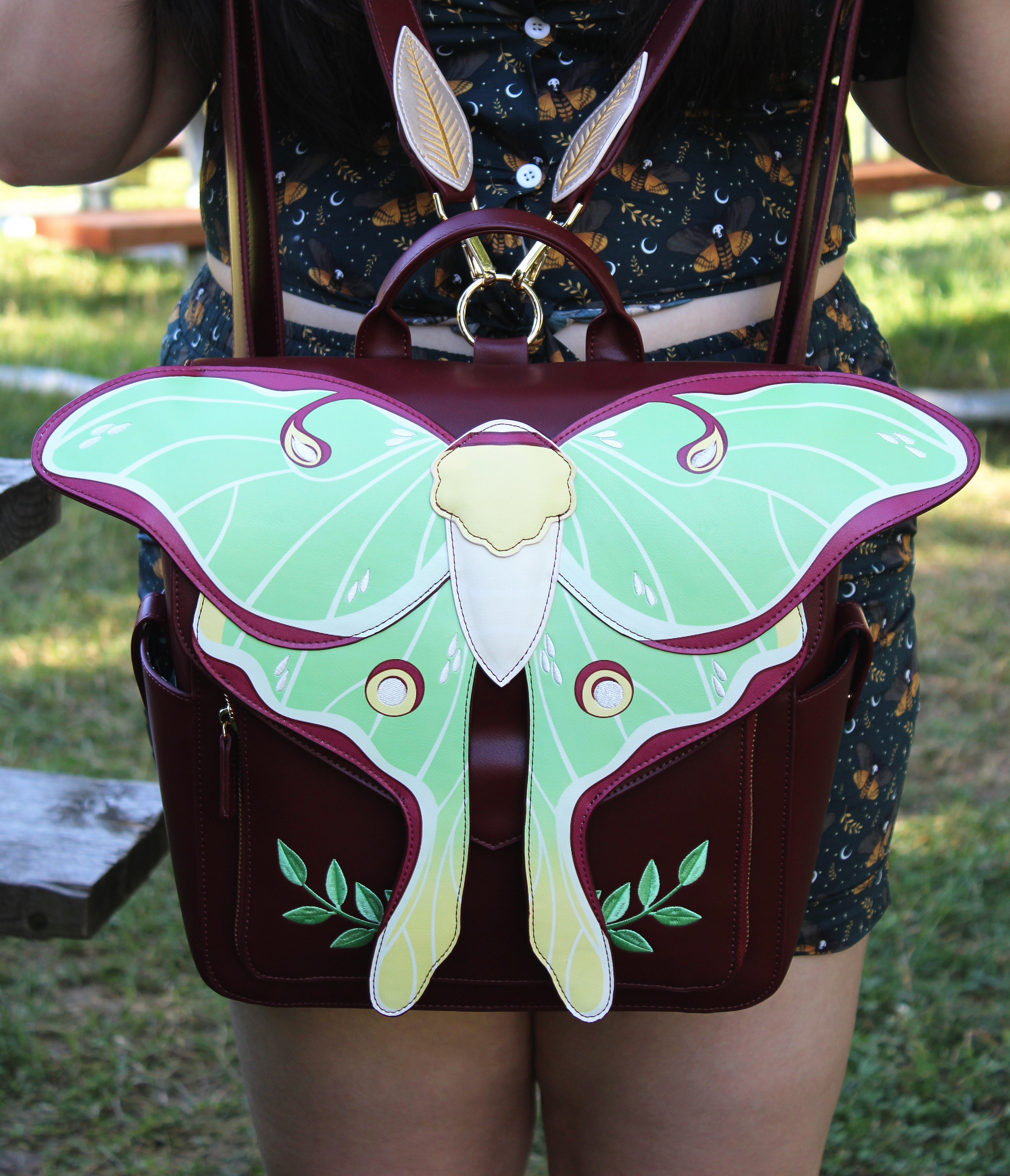 Bag with a butterfly design held by a person outdoors
