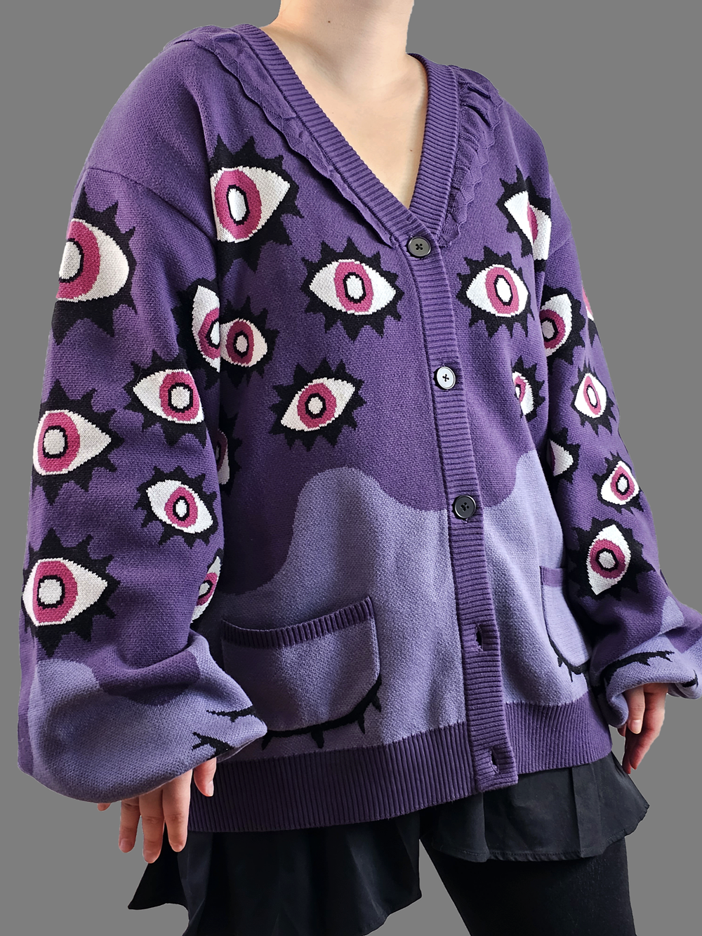 Model wearing the Abyss Cardigan in purple with bold all-over eye motifs and oversized fit. 100% cotton knit by Nyahallo.