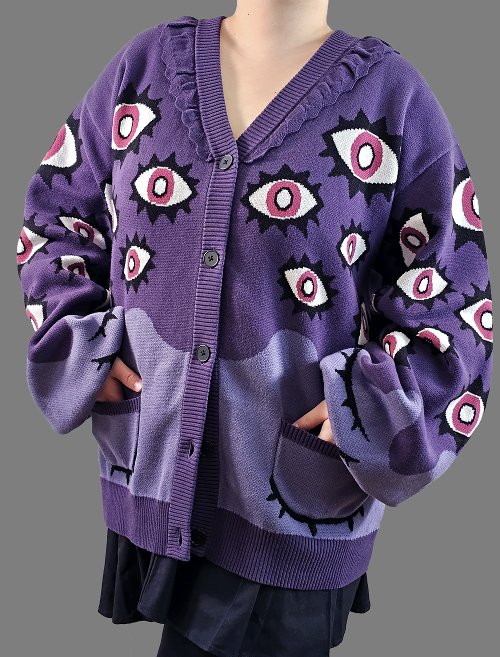 Front view of the Abyss Cardigan featuring bold purple knit with all-over eye motifs, oversized fit, and deep pockets.