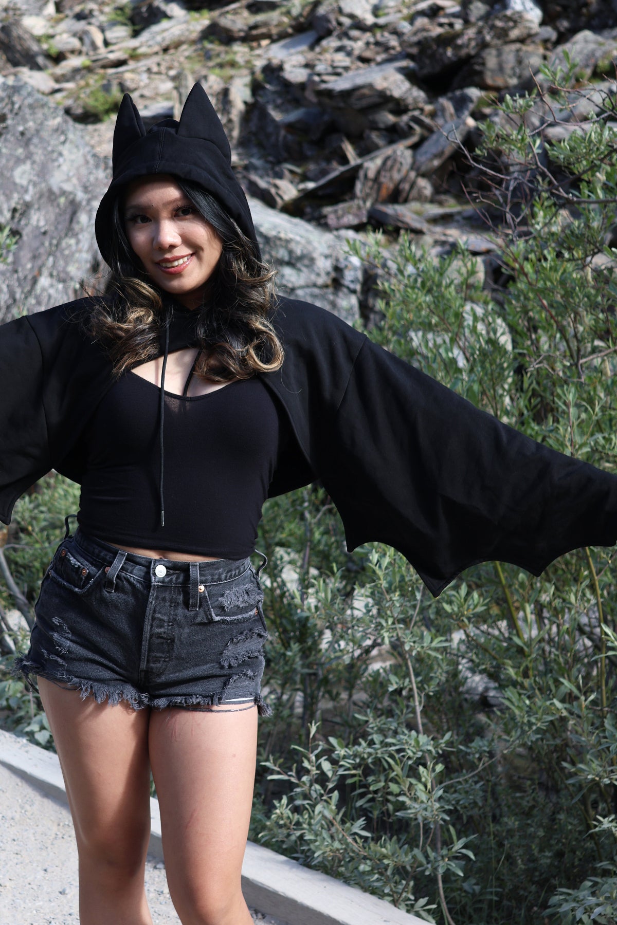 Close-up of the Nyahallo Bat Shrug with bat ears on the hood and oversized bat wing sleeves, showcasing the dramatic wing-inspired design.