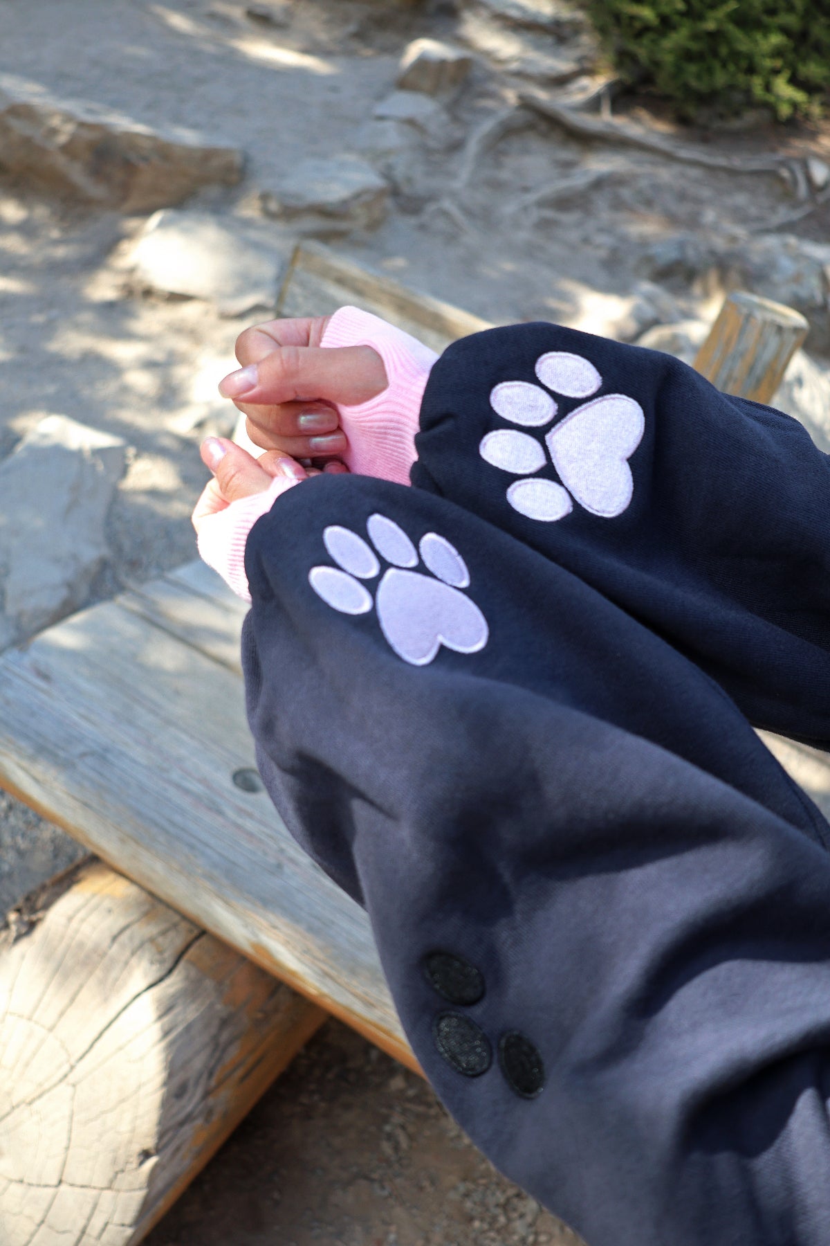 Close-up of the Nyahallo Cat Shrug sleeves featuring embroidered pink cat paw prints and oversized cuffs.