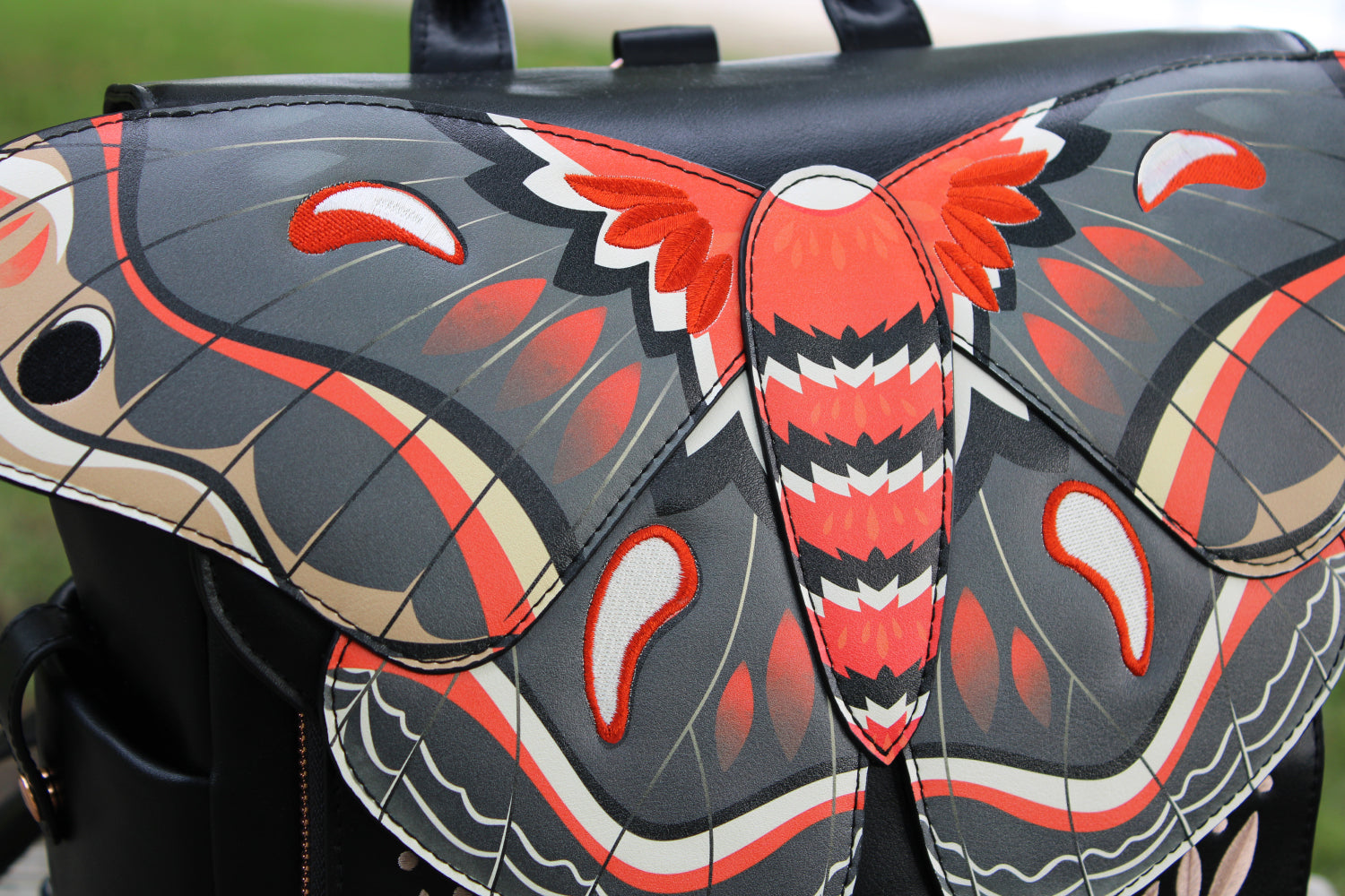 Close-up of a cecropia moth backpack featuring detailed wing artwork inspired by entomology fashion and whimsical fairycore aesthetics