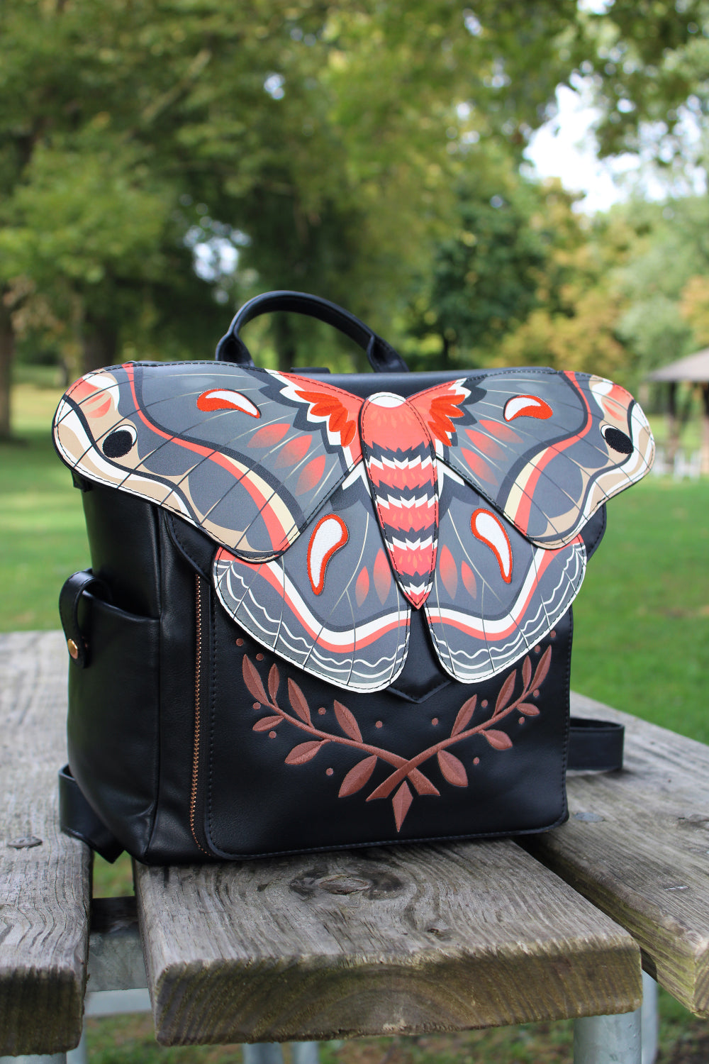 Black cecropia moth backpack with whimsical fairycore and forestcore aesthetic, featuring botanical woodland inspired artwork.