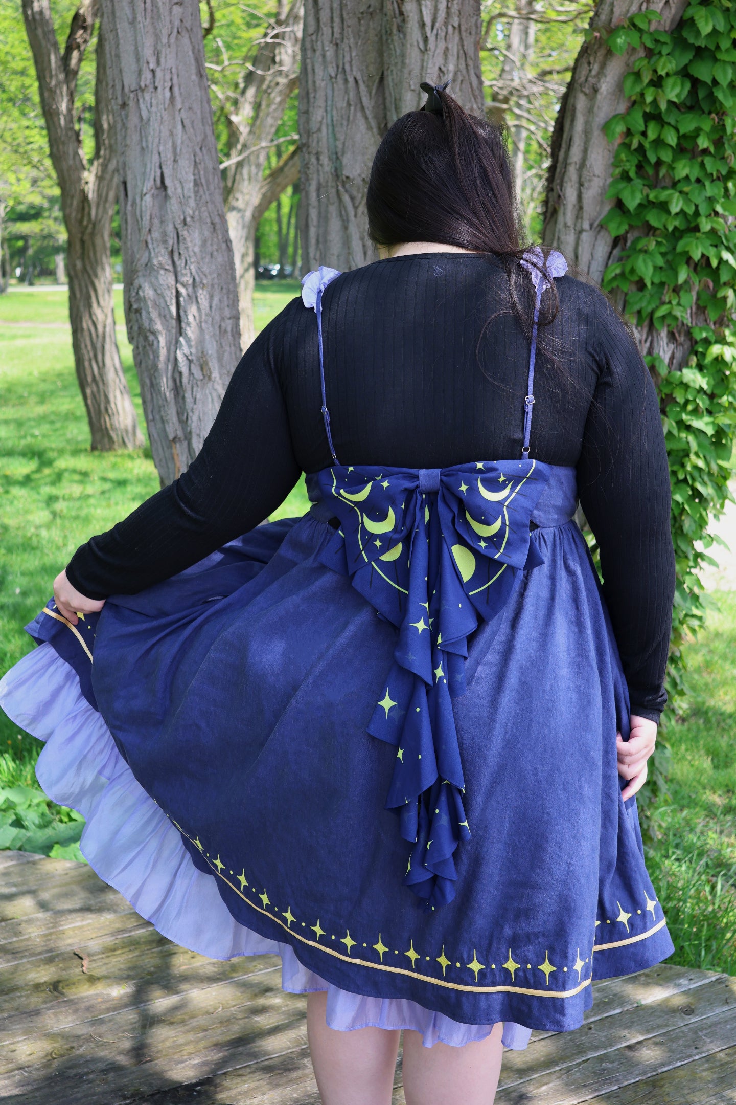 Back view of the Cosmic Moth Dress featuring a celestial moon and star bow, layered skirt, and whimsical fairycore design