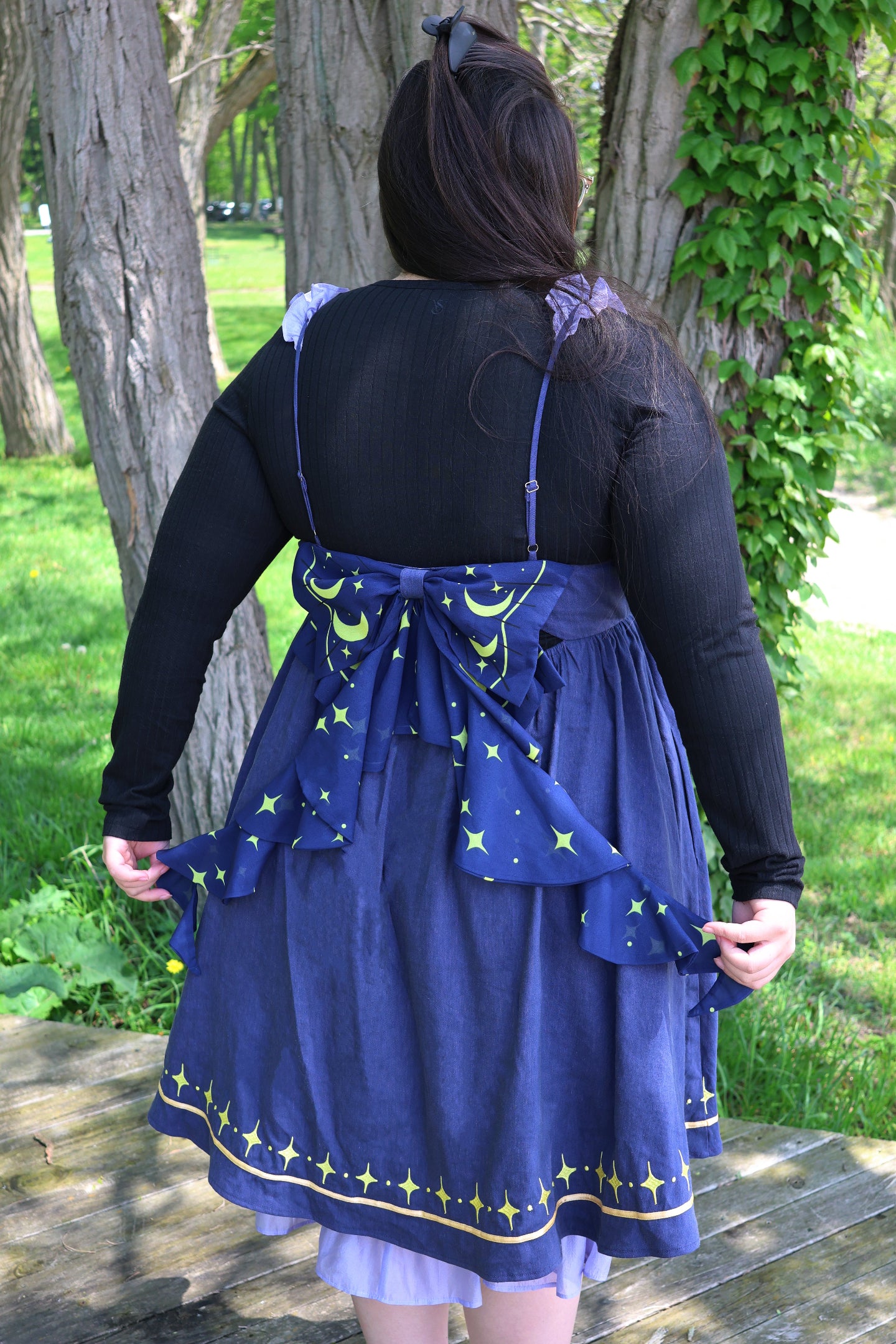 Back view of the Cosmic Moth Dress featuring a moon and star print bow, adjustable straps, and celestial fairycore styling