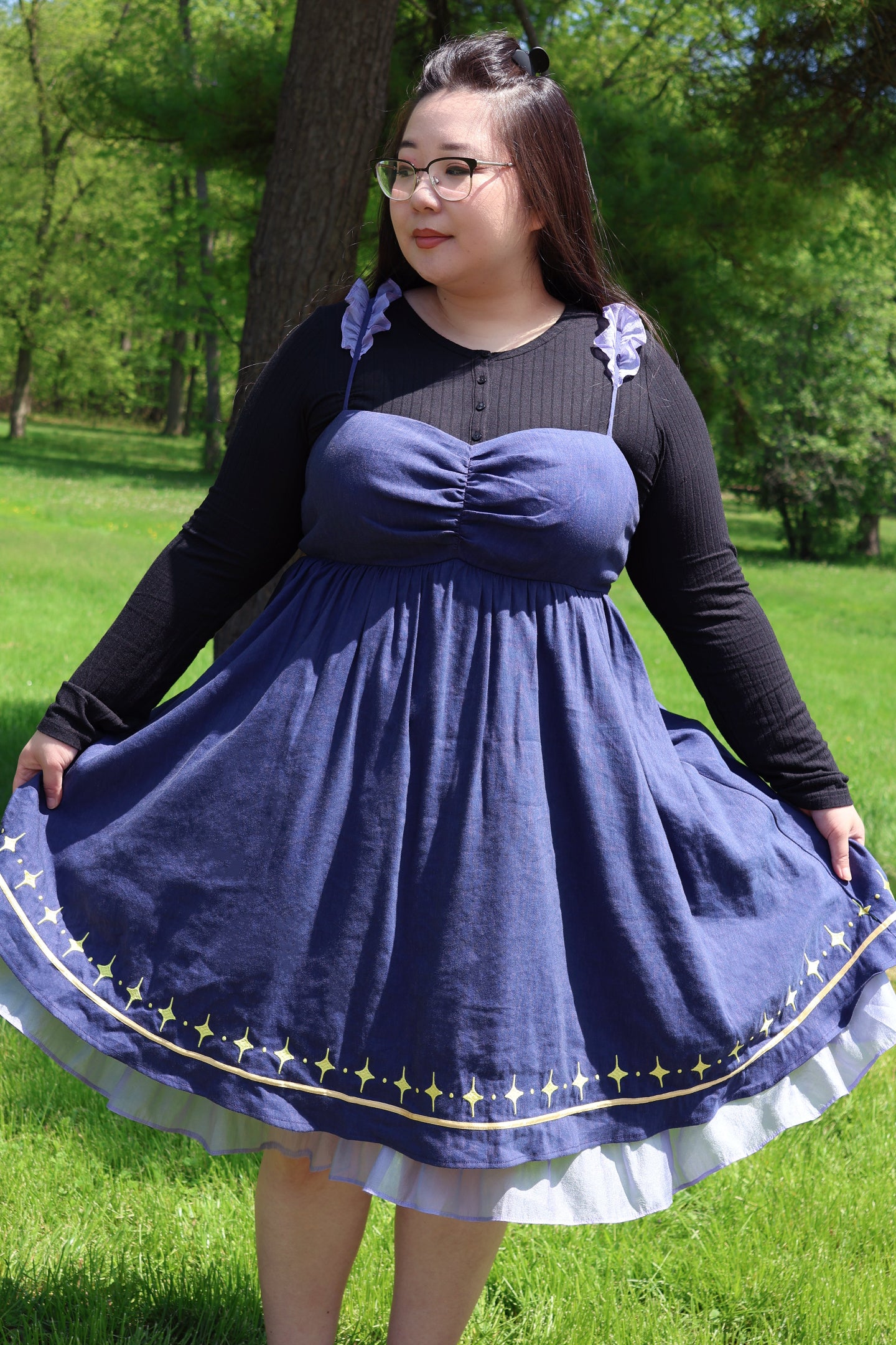 Model wearing the Cosmic Moth Dress featuring a ruched bodice, celestial star hem, and layered fairycore skirt in a woodland setting