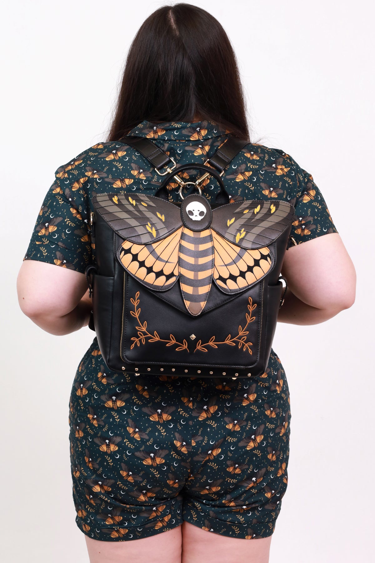 Model wearing the Death's-Head Hawkmoth Backpack with matching Death's-Head Hawkmoth top and shorts, showcasing layered moth wings, skull detailing, and coordinated gothic nature-inspired artwork.