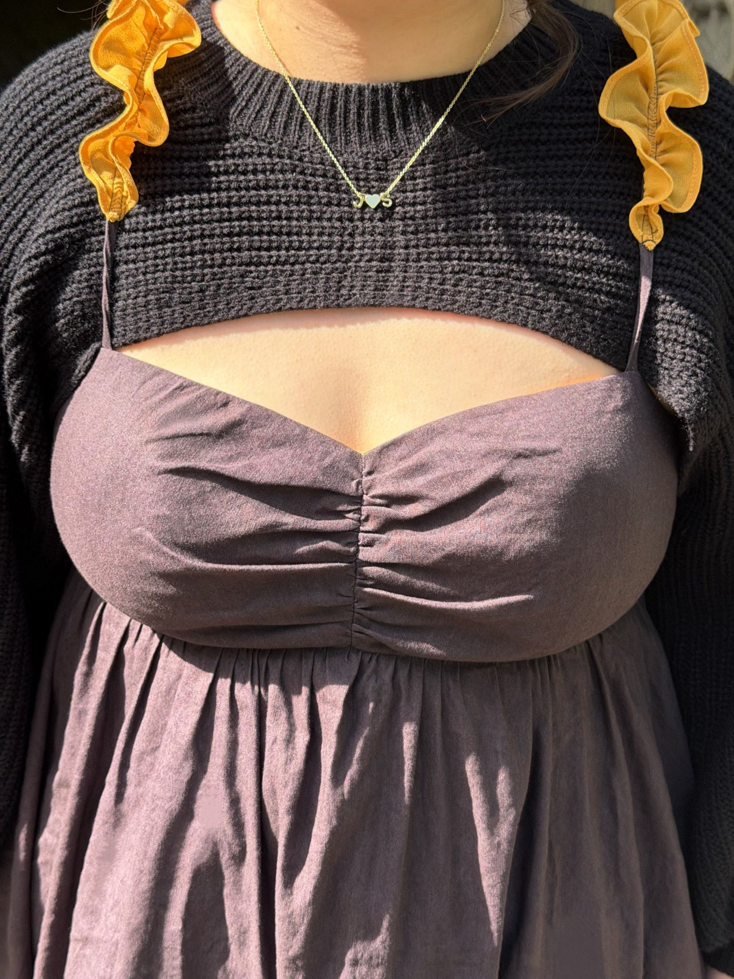 Close-up detail of the Death’s-Head Hawkmoth Dress featuring ruched bodice fabric, textured black knit sleeves, and golden ruffle shoulder straps in sunlight.