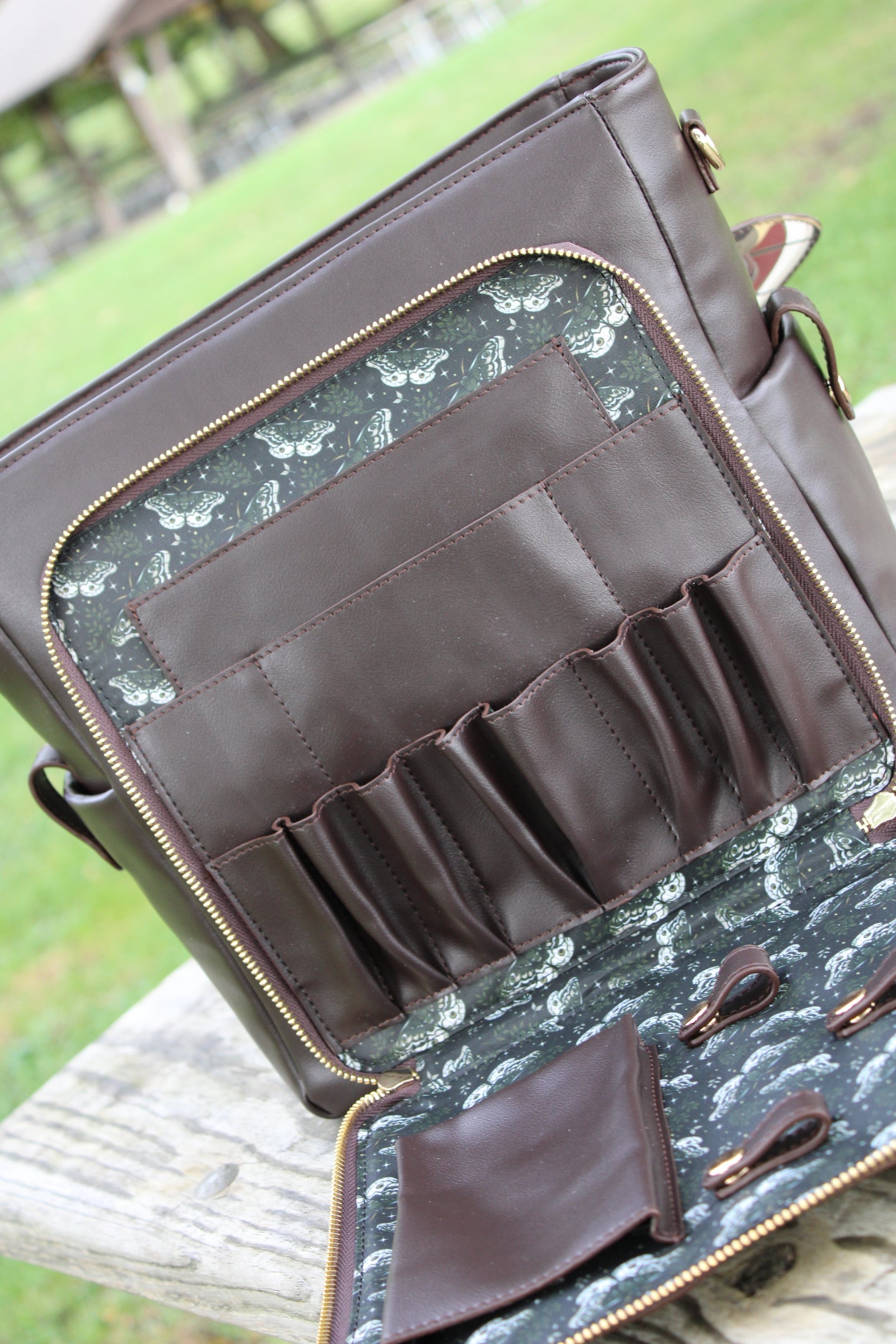 Interior view of the Emperor Moth Backpack showing multiple storage compartments, organizer pockets, and a custom moth-pattern lining.