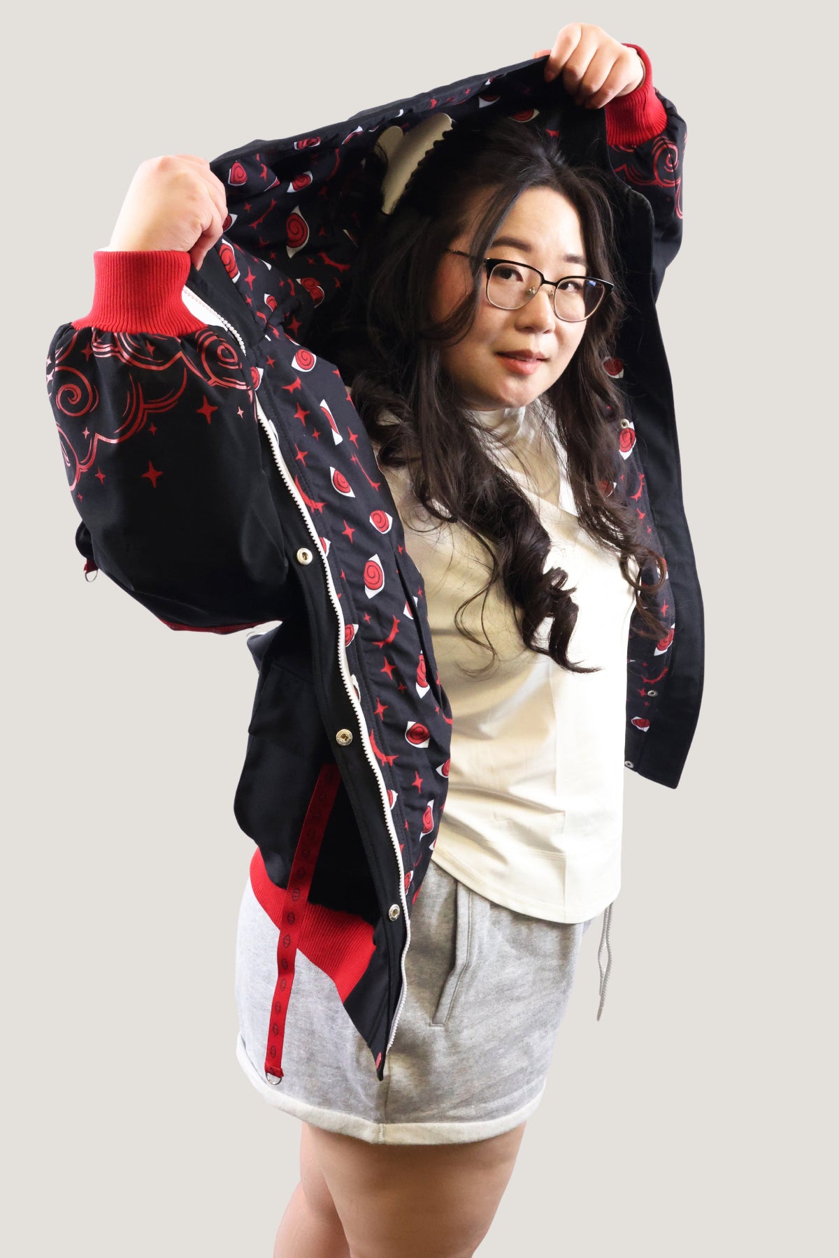 Model wearing a black jacket with red patterns on a plain background