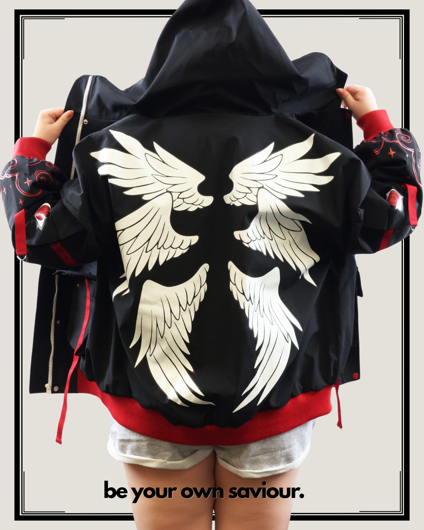 Black jacket with white wing designs and red accents, worn by a model.