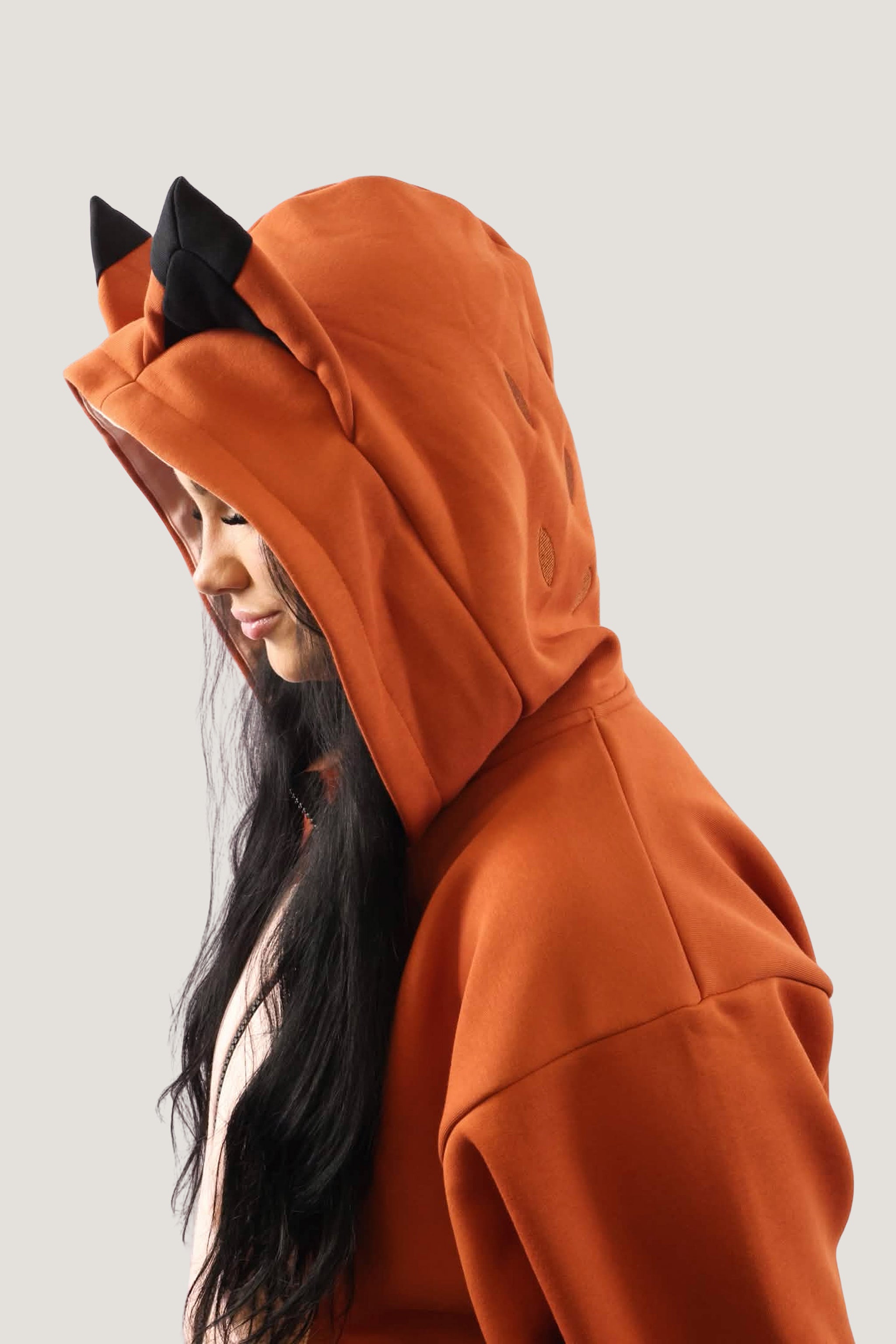 Side profile of a model wearing the Fox Hooded Sweatshirt, showing the 3D black-tipped ears and the structure of the oversized hood.