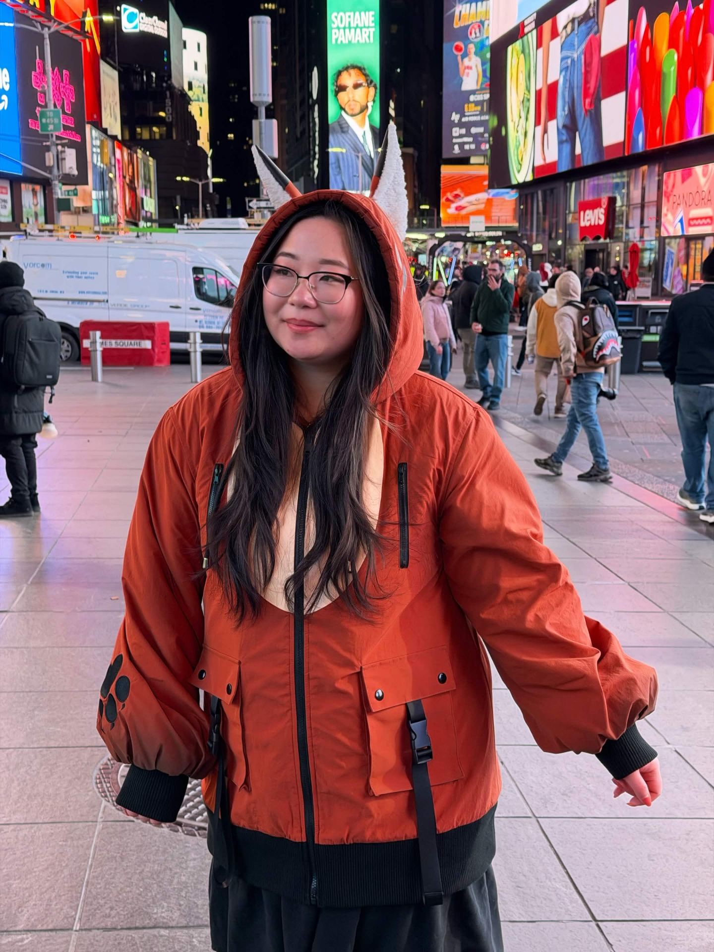 Model wearing a whimsical fox ear jacket with paw print sleeve details and woodland-inspired design in Times Square at night.