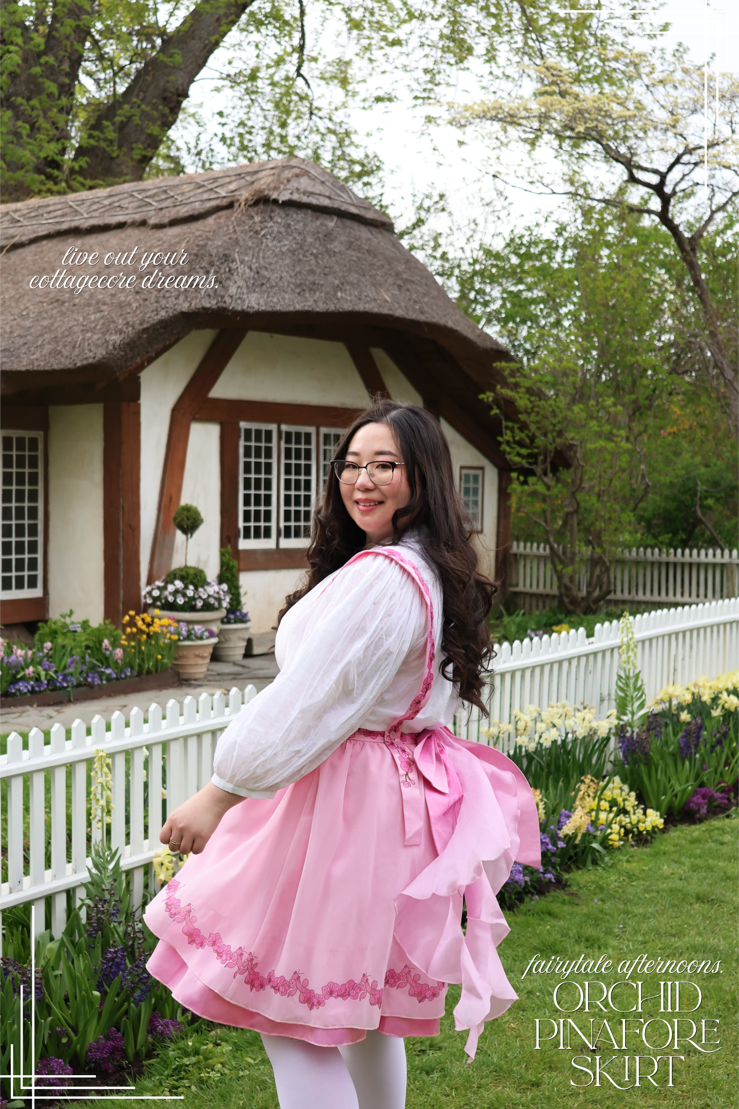 Model wearing the Orchid Pinafore Skirt in a cottagecore garden setting with a pink layered skirt and oversized bow detail.