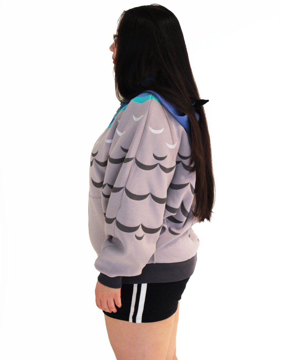 Side view of a model wearing a pigeon inspired hoodie with layered feather print sleeves and the hood down.