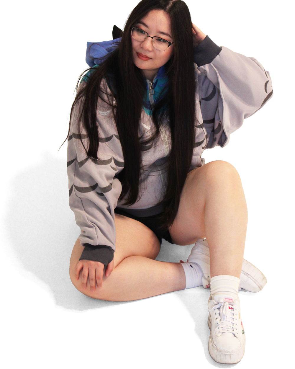 Model wearing a whimsical pigeon-inspired hoodie with wing sleeve details and blue accents while sitting against a white background.
