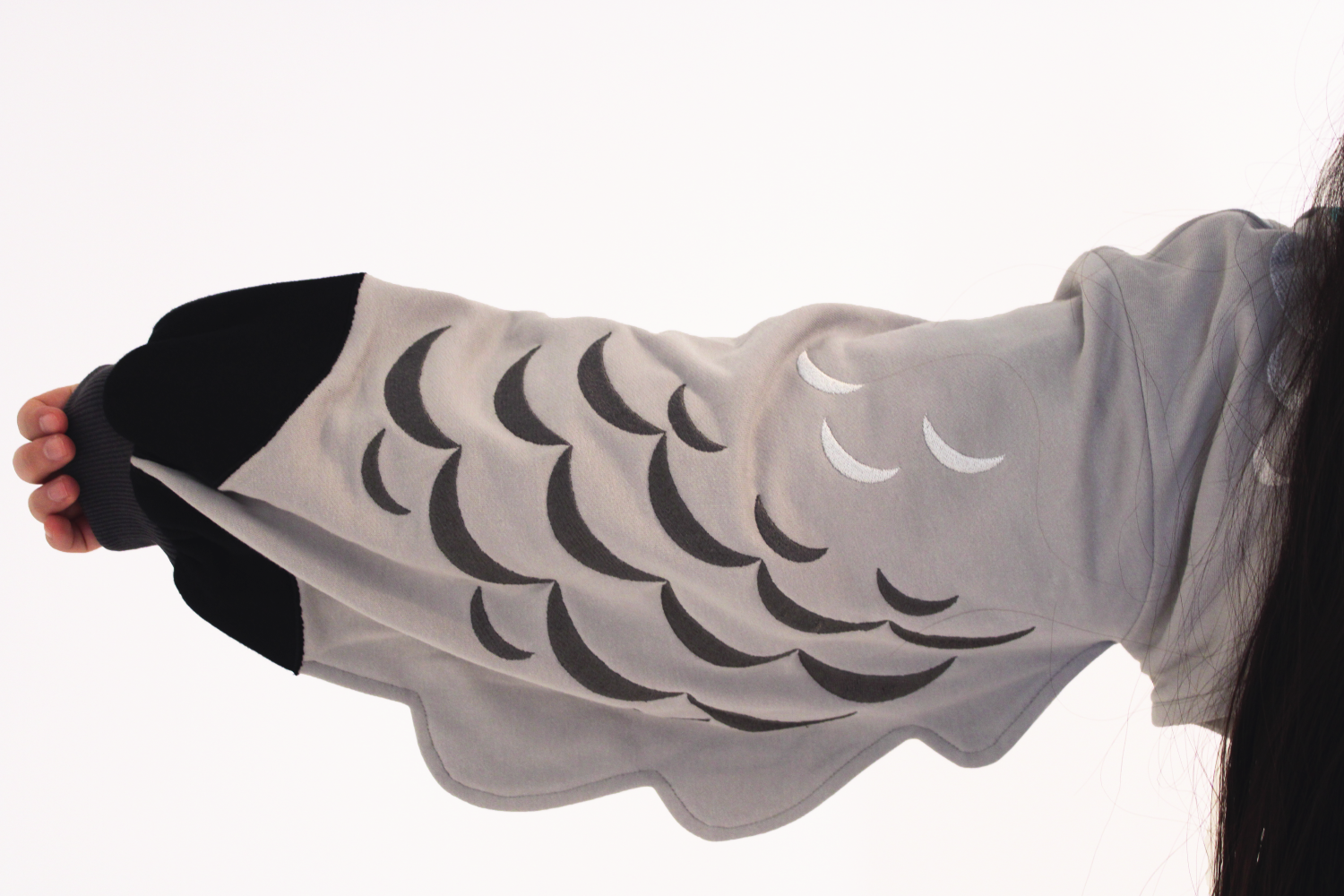 Close-up of a whimsical pigeon-inspired sleeve featuring feather-like markings and wing-shaped cuffs.