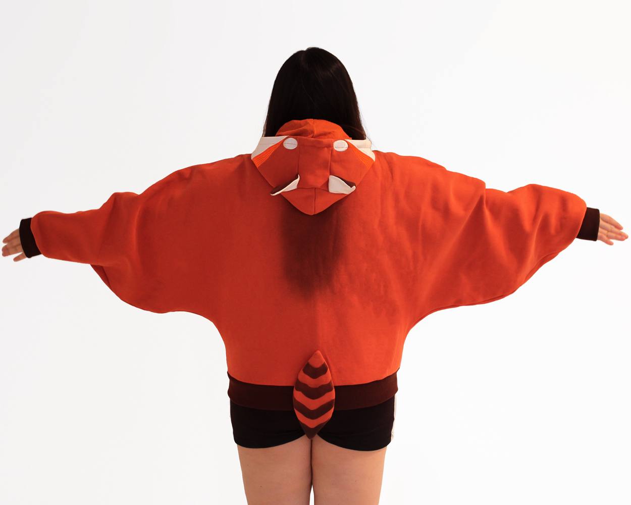 Back view of a red panda themed oversized hoodie featuring a striped tail and animal face hood detail.