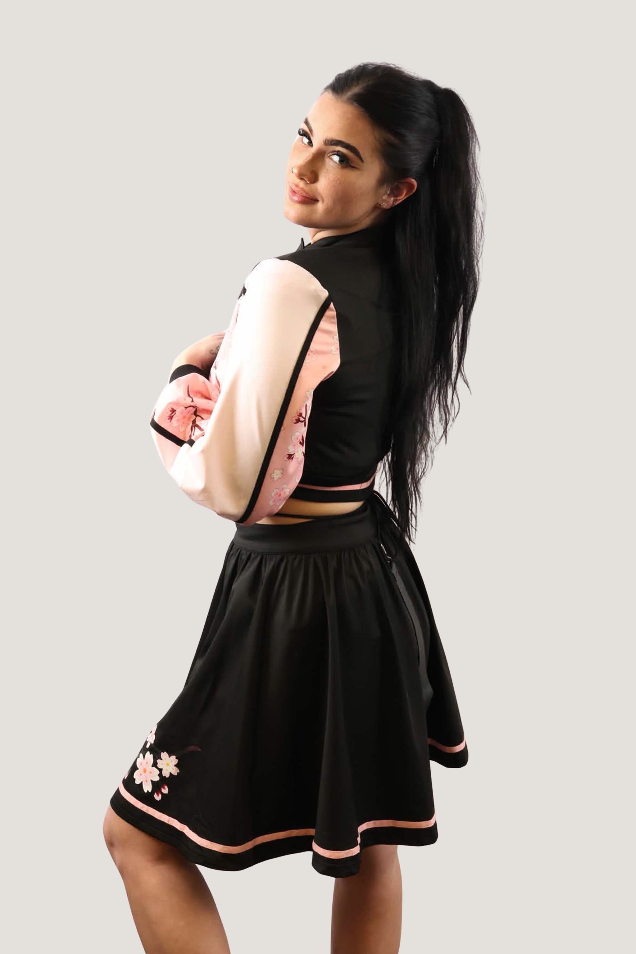 Model wearing a pink and black outfit with floral details on a plain background