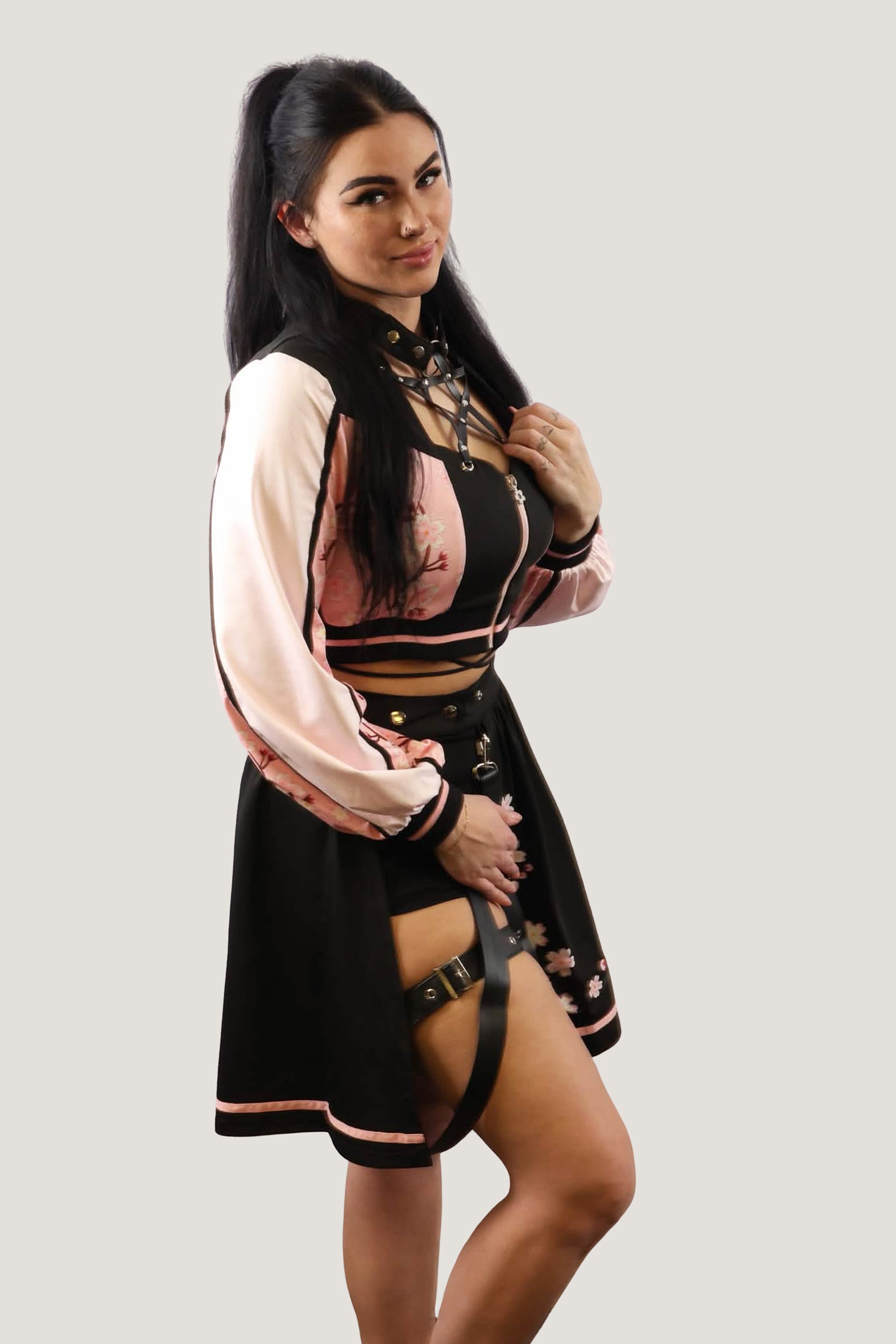 Model wearing a black outfit with floral details on a plain background