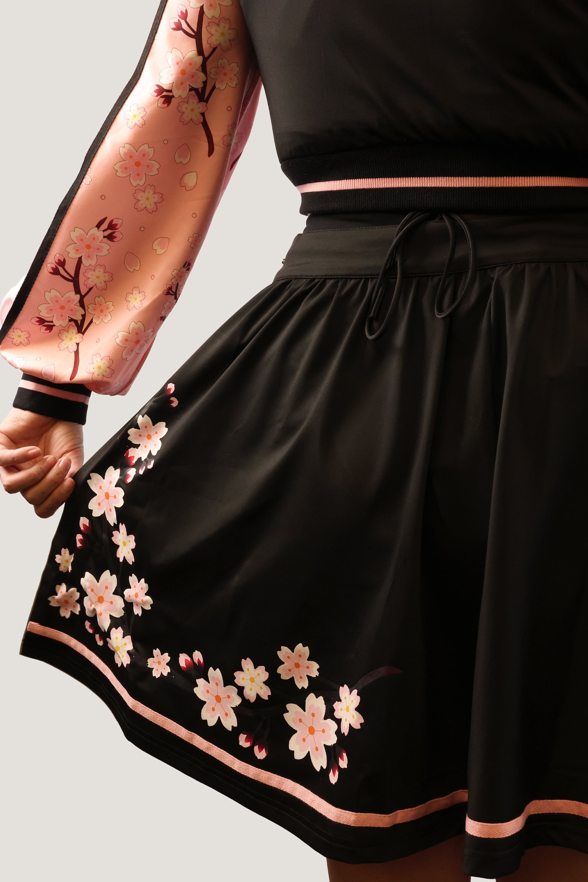 Black skirt with floral embroidery on a plain background.
