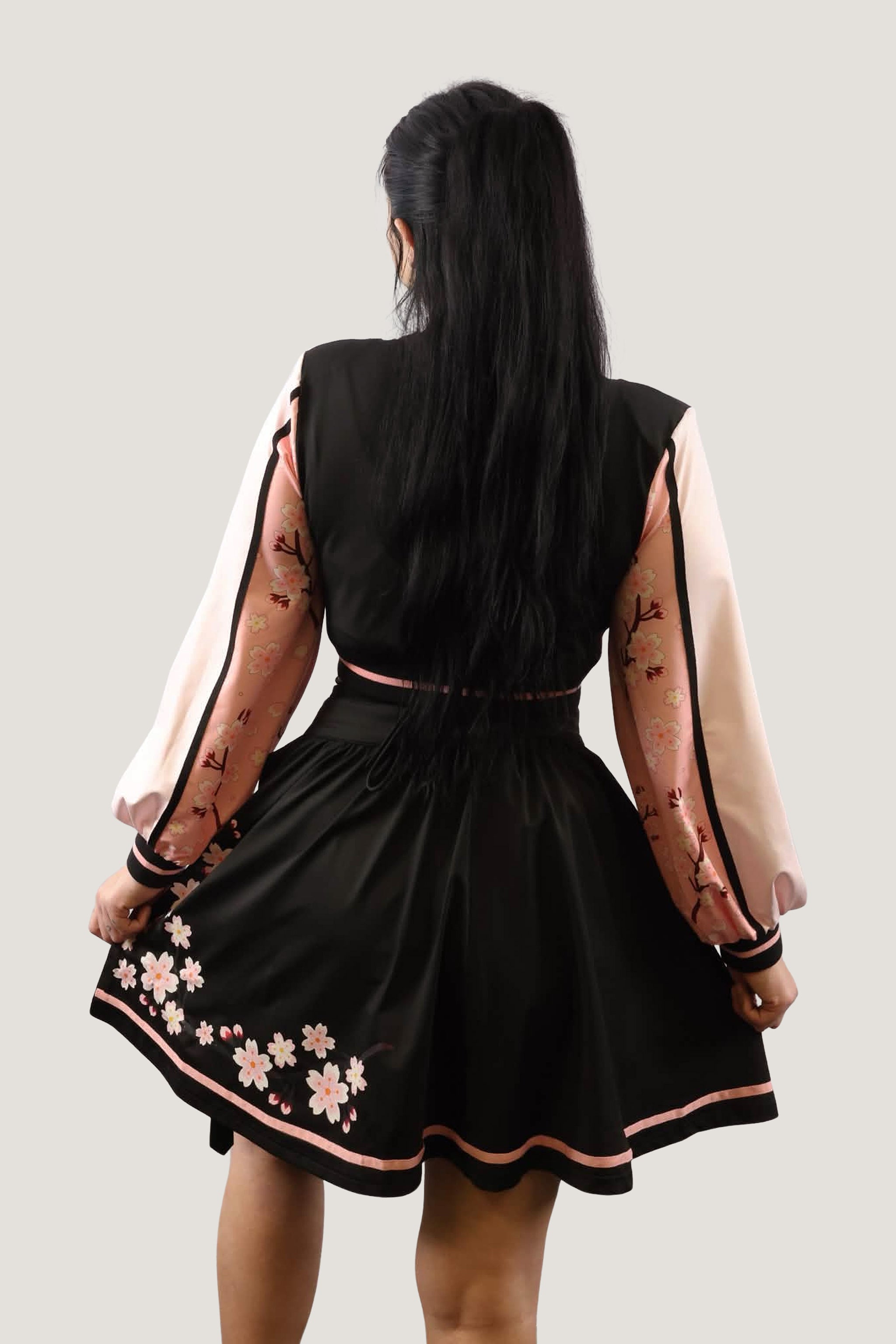 Back view of the Sakura superstar set showing the pink cherry blossom embroidery on the black skirt and floral patterns on the jacket sleeves.