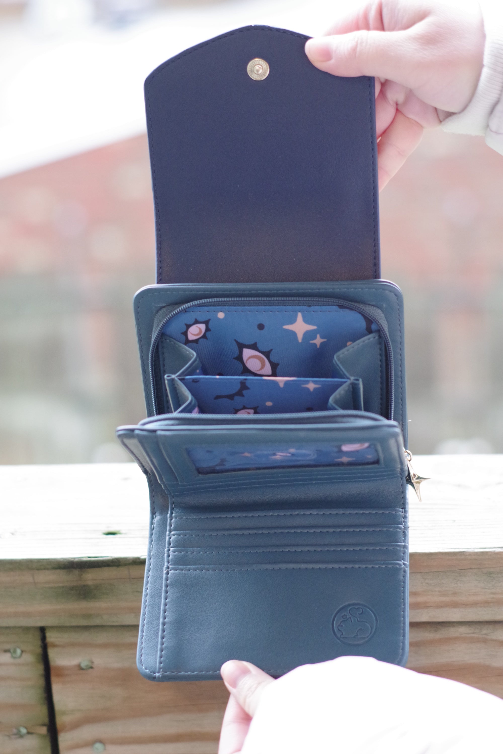 Open Seraphim celestial wallet displaying card slots, coin pouch, blue celestial lining, and compact storage compartments.