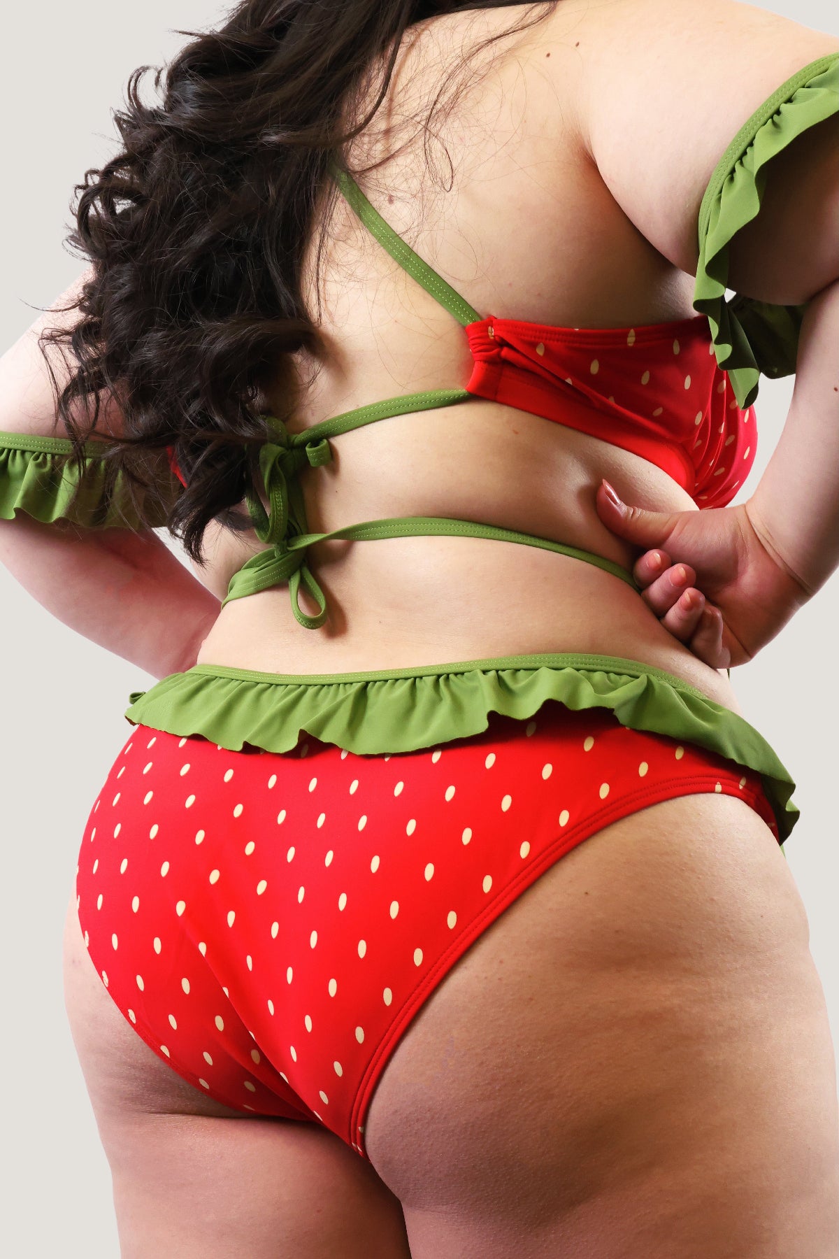 Red and green strawberry-themed bikini on a plain background