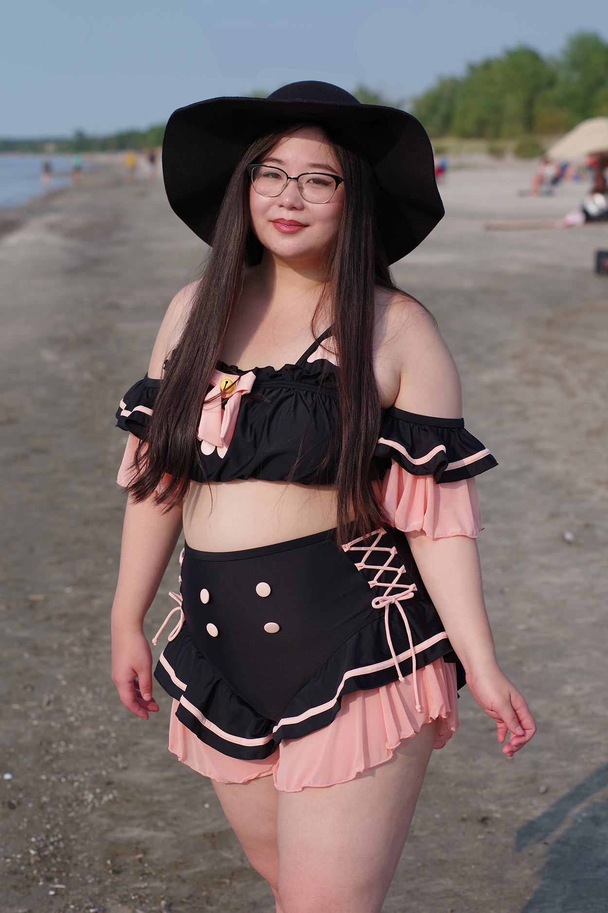 Black and pink kawaii swimsuit with frill sleeves, lace-up sides, and whimsical cat-inspired design.