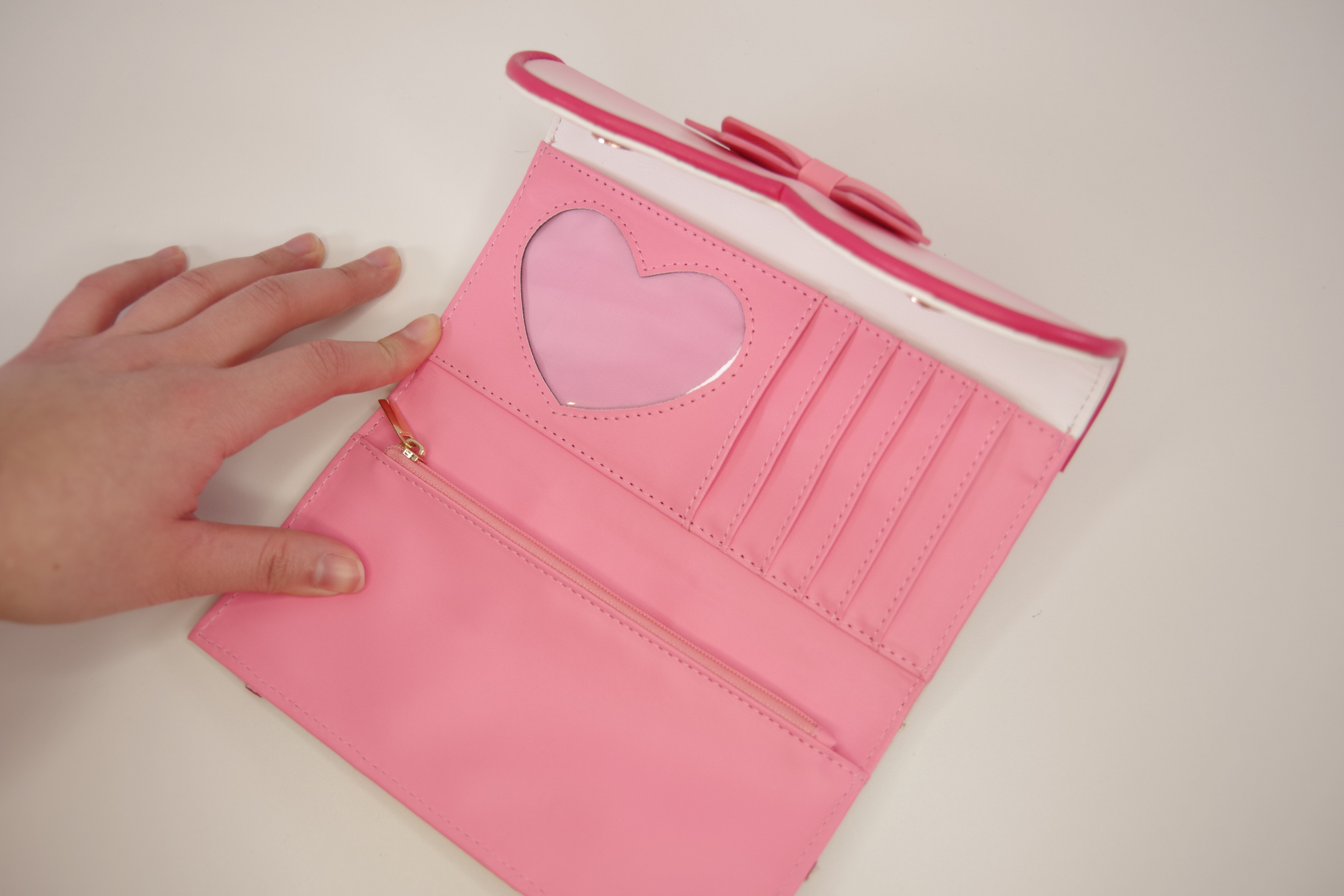 Open pink magical girl inspired wallet showing heart-shaped ID window, multiple card slots, zippered coin pocket, and spacious bill compartment.