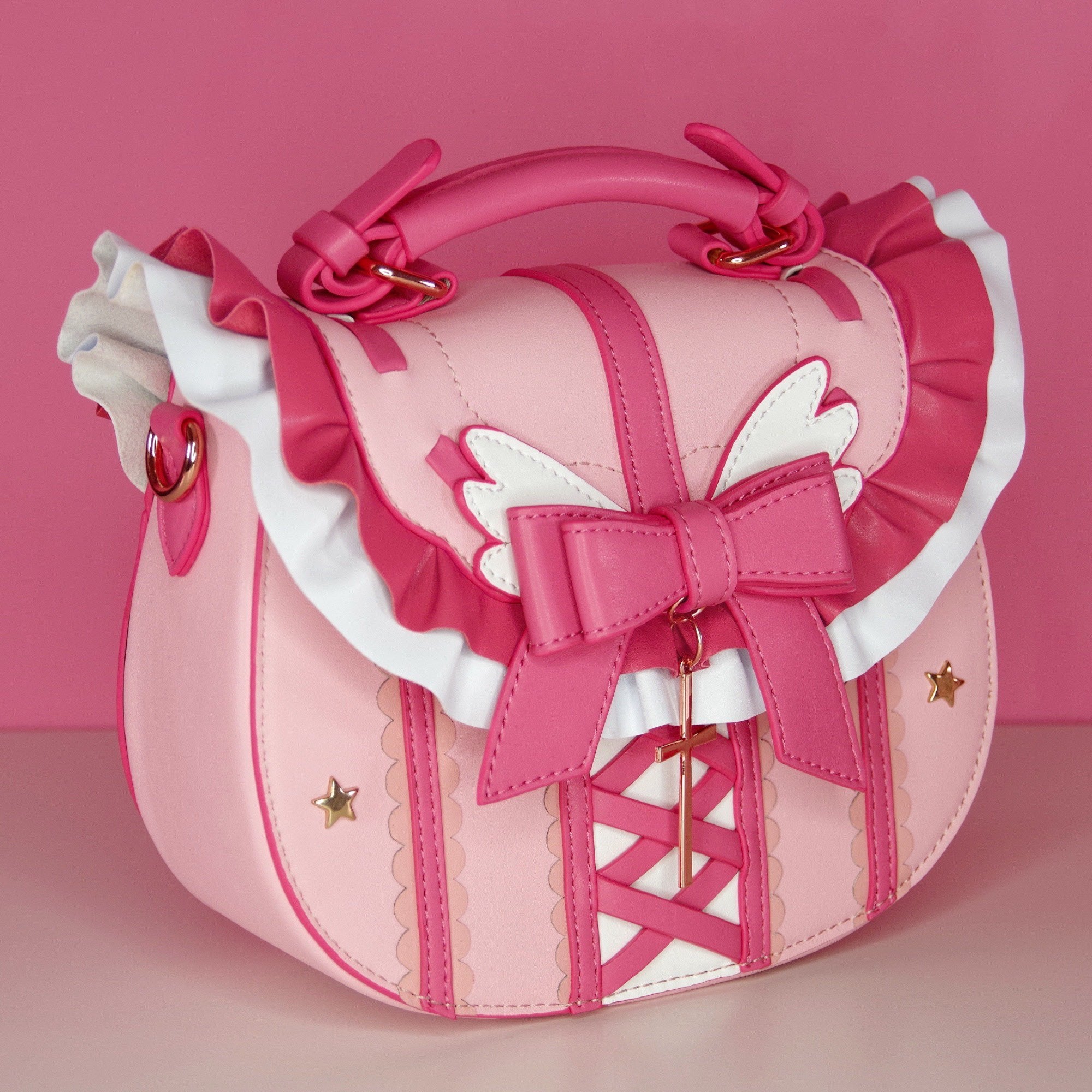 Pink handbag with bow and decorative elements on a pink background